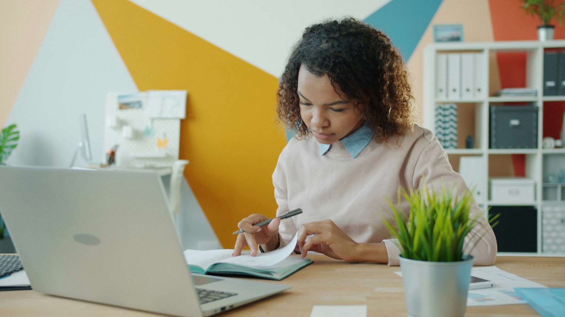 A grant writer reviewing a document at her desk